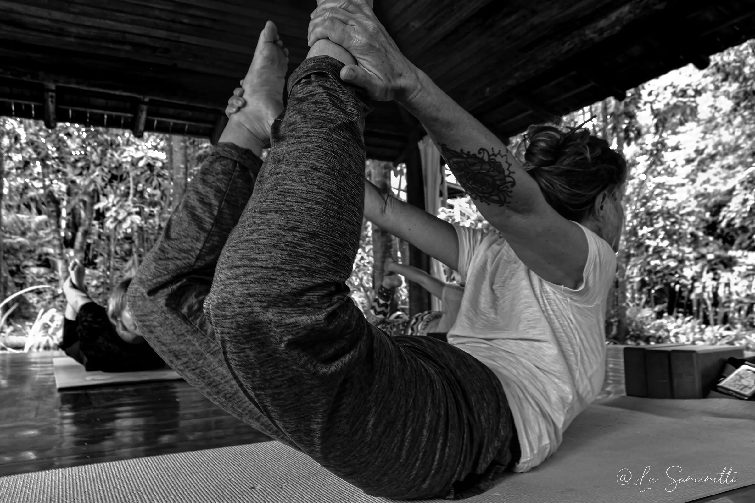Praticante em postura de yoga no pavilhão aberto, em preto e branco