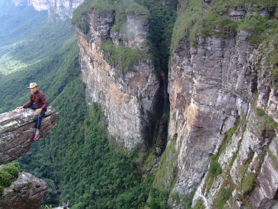 Caminhante sentado em um mirante rochoso sobre o Vale do Pati