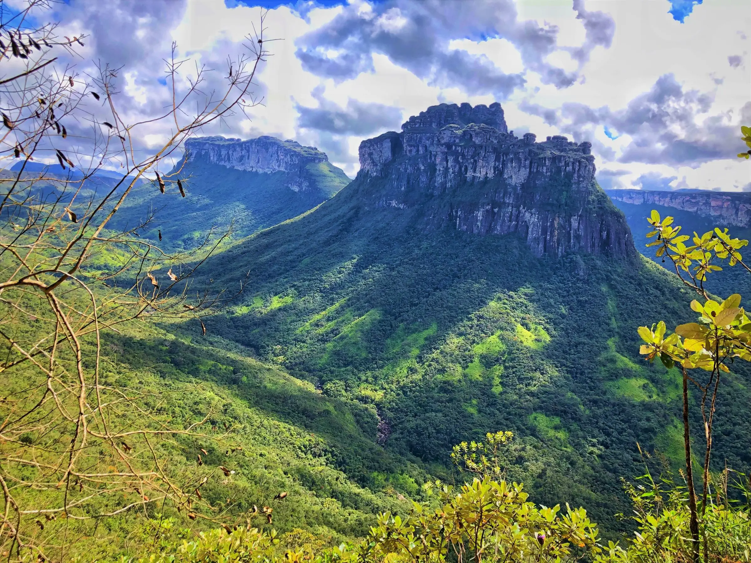 View over Vale do Pati, with sandstone cliffs above the green valley and a cloudy sky