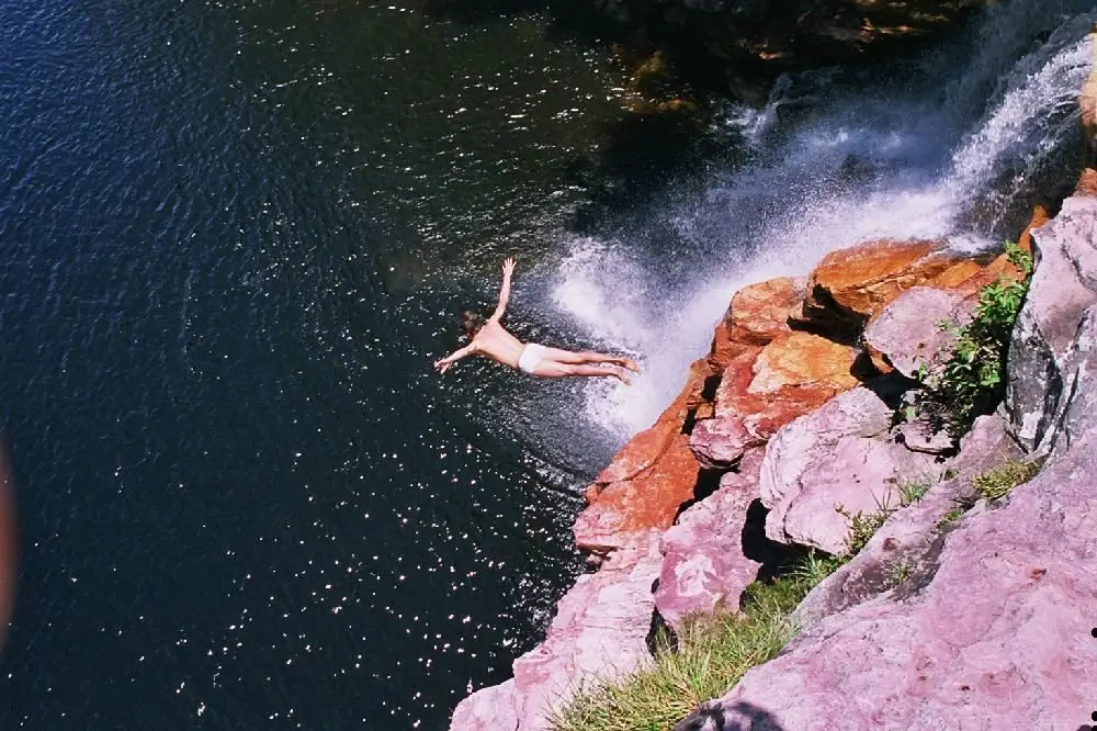 Guia saltando em um poço de cachoeira na Chapada Diamantina