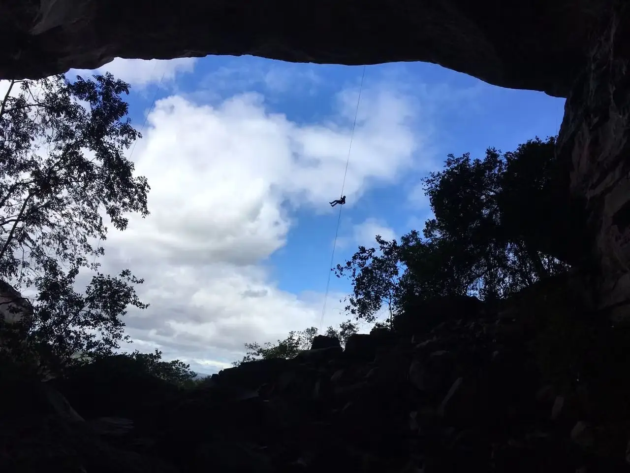 Descida de rapel por uma abertura de caverna na Chapada Diamantina