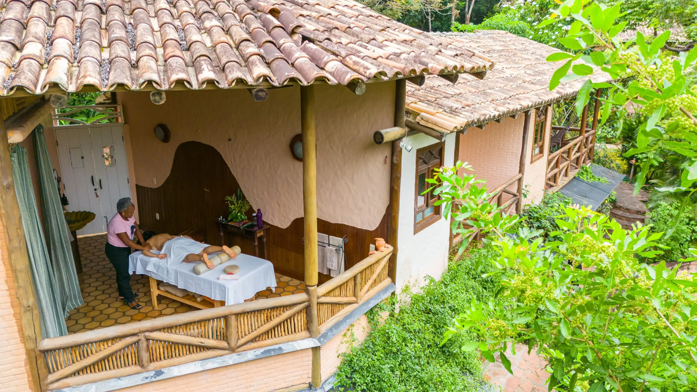 Massage on the veranda of a bungalow surrounded by greenery